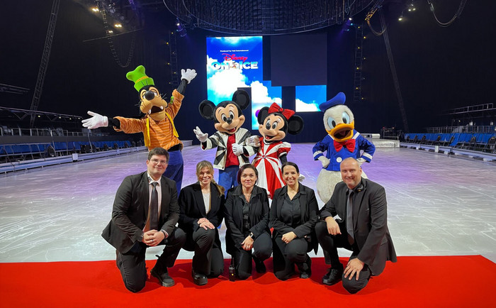 Mitarbeiter von XXL-Sicherheit gemeinsam mit Disney-Figuren in der Veranstaltungsstätte auf dem Eis